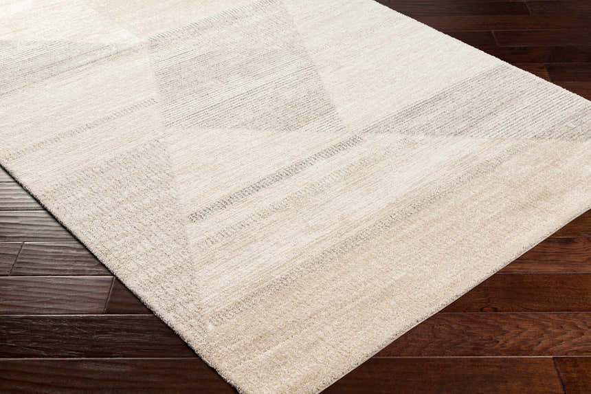 Close up of the Chizu Geometric Neutral Luxe Rug showing bone and gray tones with a subtle geometric pattern. Corner