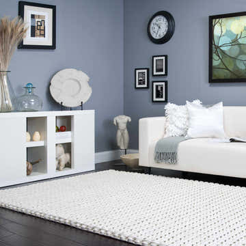 Living room scene with a cream Christoval Area Rug, white sofa, and blue walls. Contemporary style. Roomscene-Rectangle