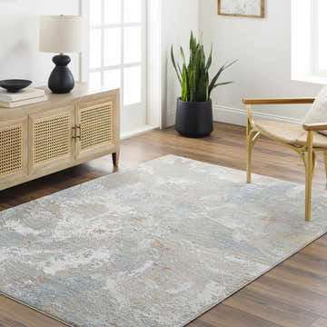 Living room scene with a Cindy Thick Luxe Boutique Rug in cloud gray, light wood cabinet, and gold accent chair. Roomscene-Rectangle