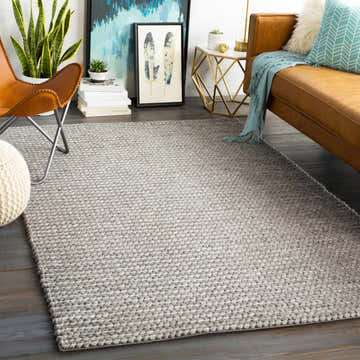 Living room scene with a brown leather couch and ivory Cirencester Area Rug in ivory and medium gray. Roomscene-Rectangle