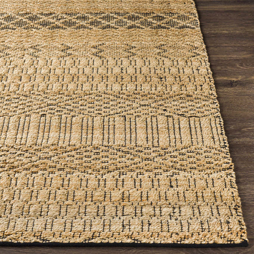 Close-up of Cloverly Tribal Jute Carpet. Hand-woven rug with black tribal pattern on tan jute. Bohemian style. Front