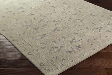 Close-up of the hand-knotted Colo Area Carpet. Charcoal and dusty sage traditional pattern on oatmeal wool. Corner