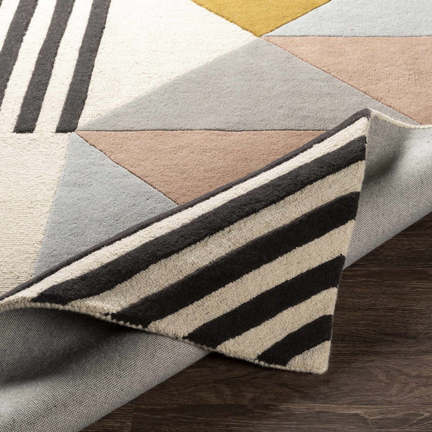 Close-up of the Coorparoo wool area rug showing its geometric design, beige, black, dusty pink, and gray colors. Fold