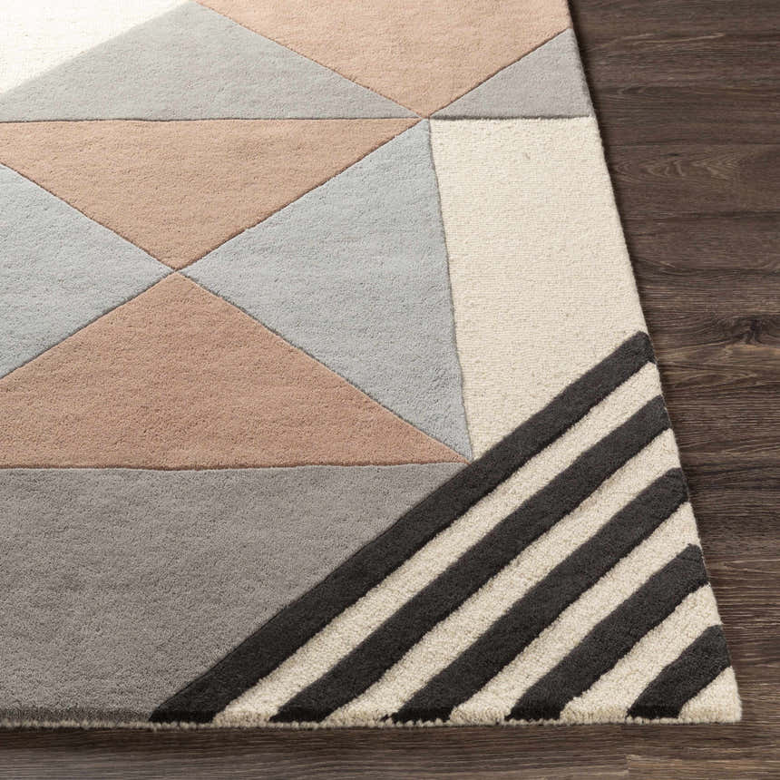 Close up of Coorparoo Wool Area Rug. Geometric design in beige, black, dusty pink, and gray on dark wood floor. Hand-tufted texture. Front