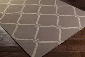 Close-up of the Coraopolis Area Carpet in light gray and taupe with a contemporary lattice design on dark wood floors. Corner