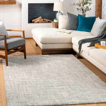 Living room scene with a light gray Cowbridge Area Rug, cream sofa, and wood accents. Roomscene-Rectangle