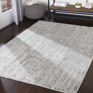 Living room scene with gray Cozahome Faux Silk Rug, dark wood floors, gray knit ottoman, and wood console table. Roomscene-Rectangle