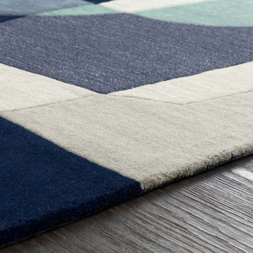Close up of the Crawfordsville rug showing the hand tufted wool texture and geometric pattern in dark blue, denim, and gray. Texture