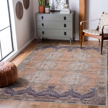 Living room scene with a Carrabelle Peach Washable Area Rug, gray dresser, leather pouf, and woven chair. Roomscene-Rectangle
