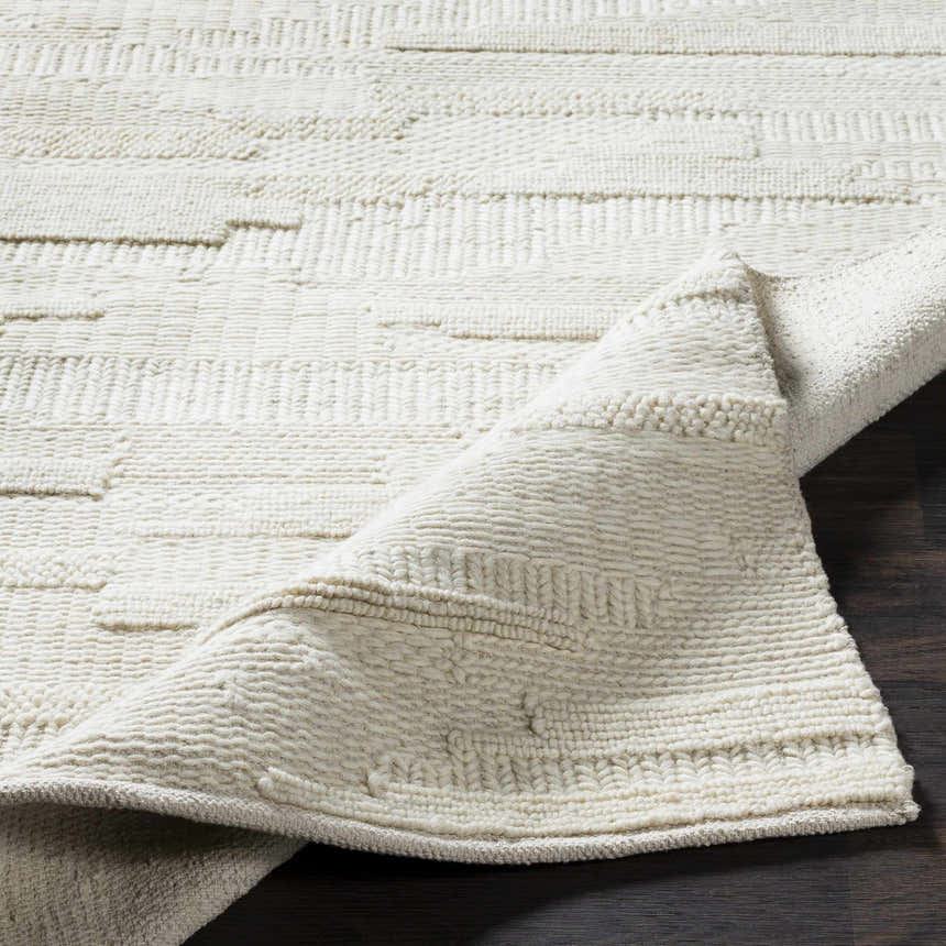 Close-up of the Cypress Cream Textured Wool Rug showing its hand woven texture and natural fibers. Fold
