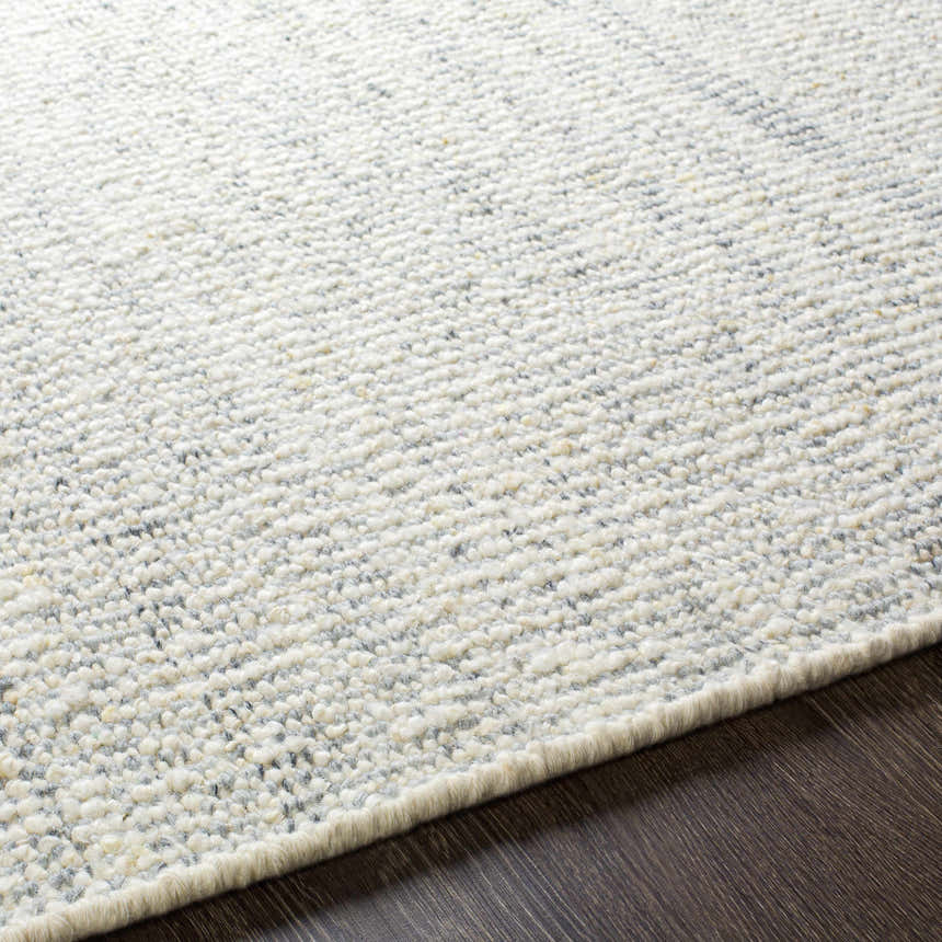 Close up of the Dalaoig Flat Woven Wool Rug. Cream and charcoal wool rug with a subtle, textured design. Texture