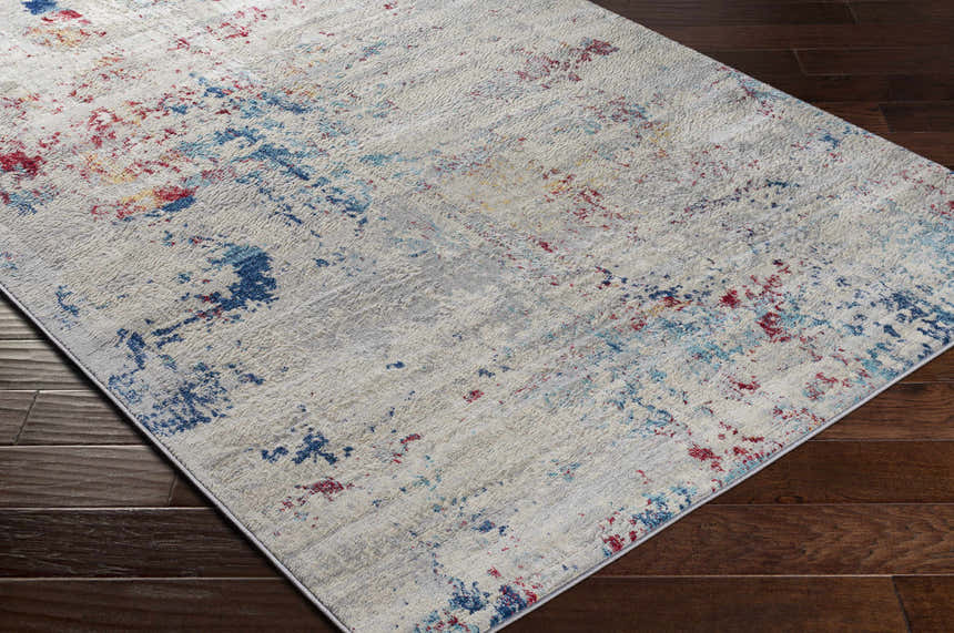 Close-up of the Dalorong Area Carpet. Features a contemporary design with dark blue, red, and beige accents. Machine woven texture. Corner