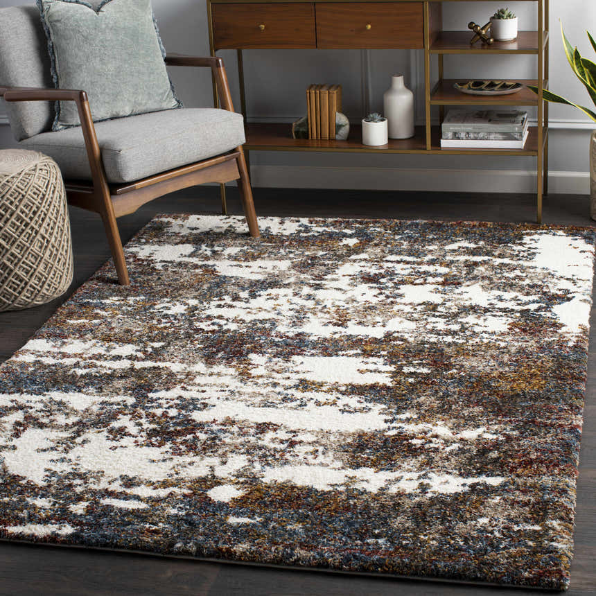 Living room scene with a contemporary Darenth Area Rug. Features a gray chair, wood console table, and a white, burgundy, and blue shag rug. Roomscene-Rectangle