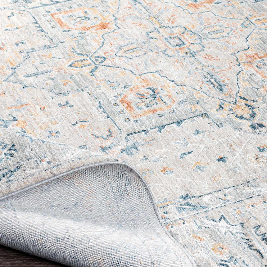 Close-up of the Darvel Luxe Rug showing its traditional Persian pattern in brick red, teal, and light gray. Fold