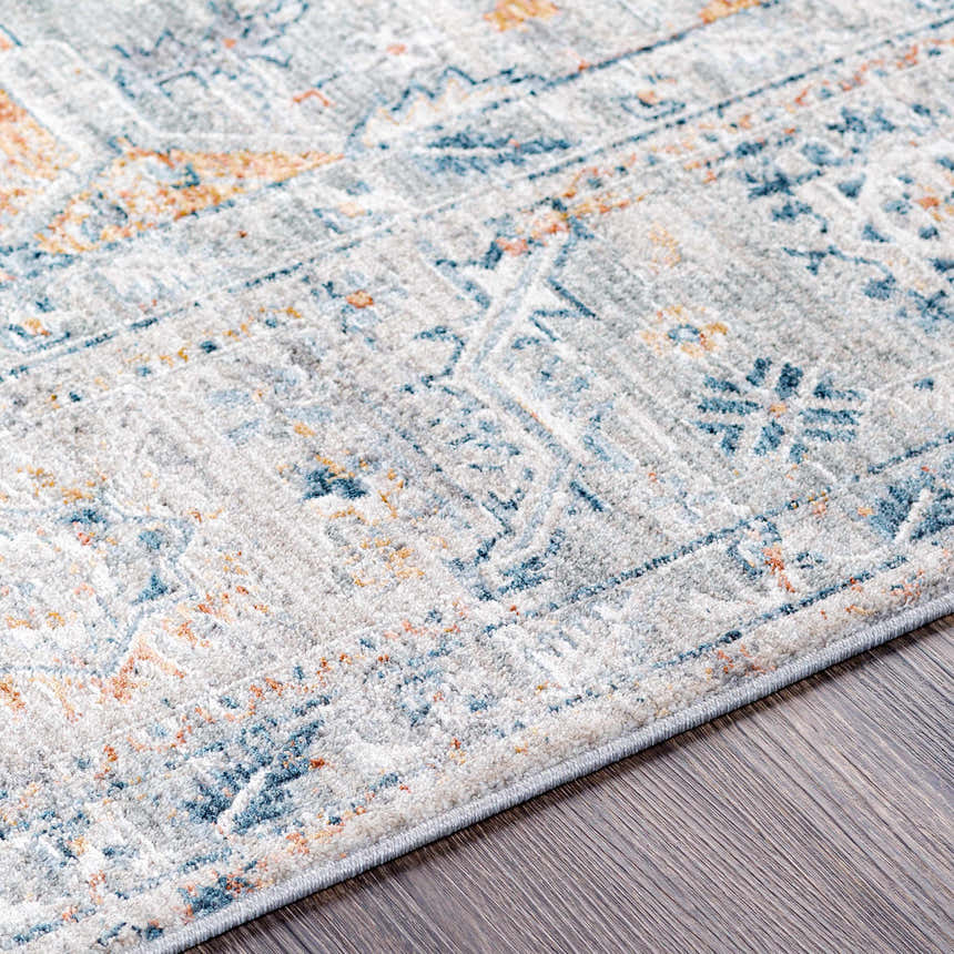 Close-up of the Darvel Luxe Rug showing its Persian-style pattern in cream, gray, teal, and mustard on a wood floor. Texture