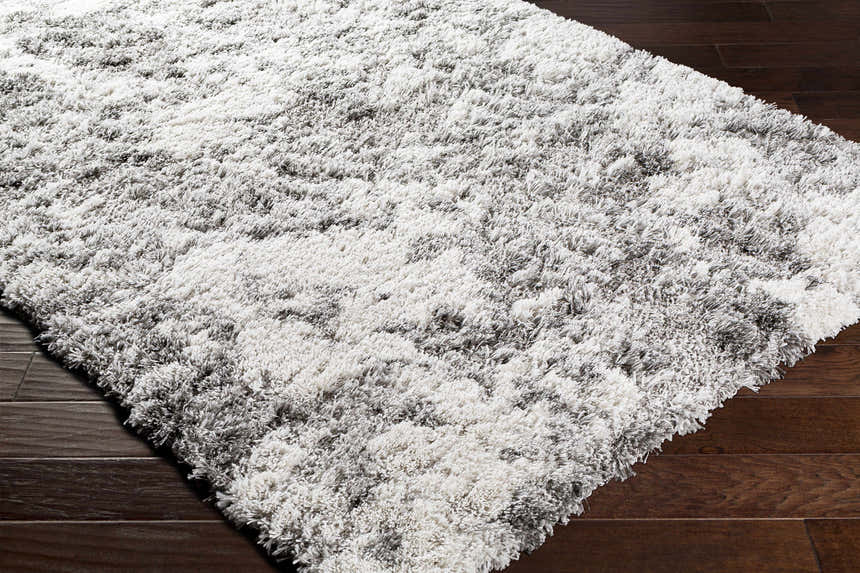 Close-up of the plush Dawesville Gray White Shag Area Rug showing its soft texture and gray and off-white color variations. Corner