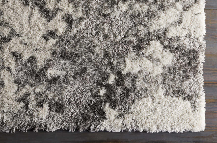 Close-up of the plush Dawesville Gray White Shag Area Rug showing its soft texture and gray and off-white pattern. Corner