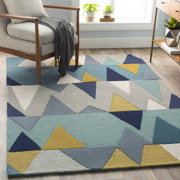 Living room scene with the Deatsville Wool Area Rug, featuring blue, gray, navy, tan, and teal geometric shapes. Mid-century modern style. Roomscene-Rectangle