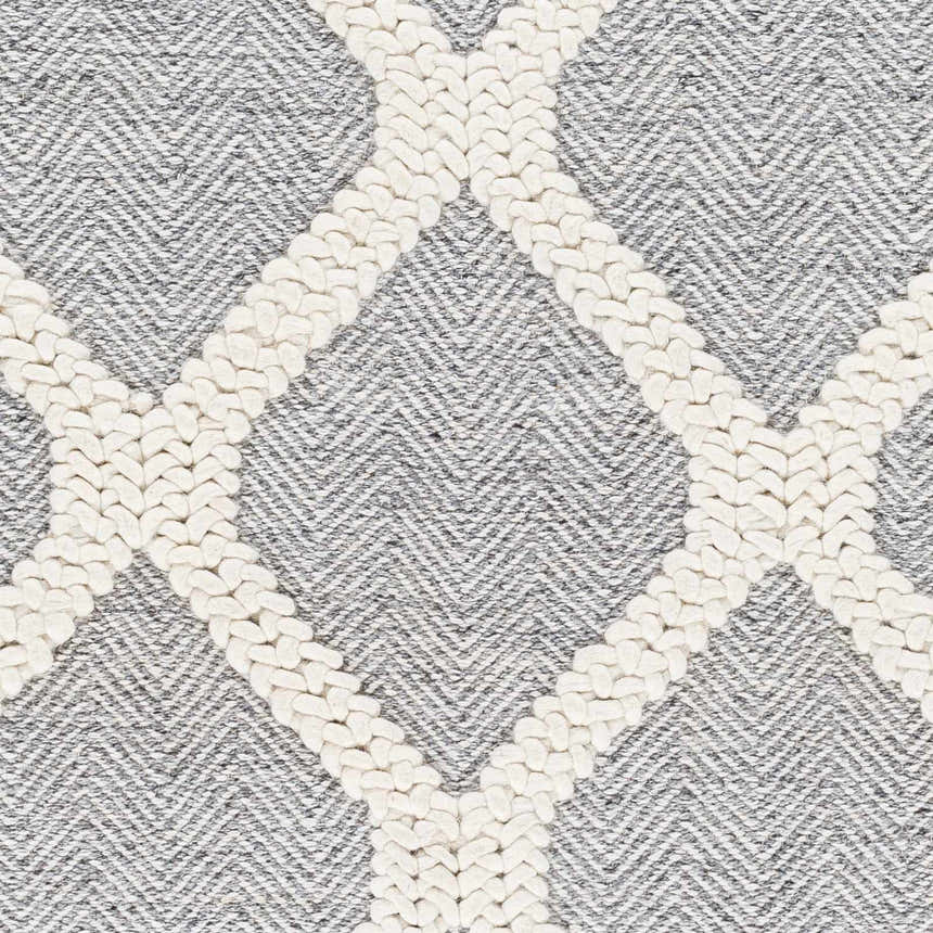 Close-up of Della Area Rug showing gray herringbone pattern and raised, braided white geometric design. Swatch