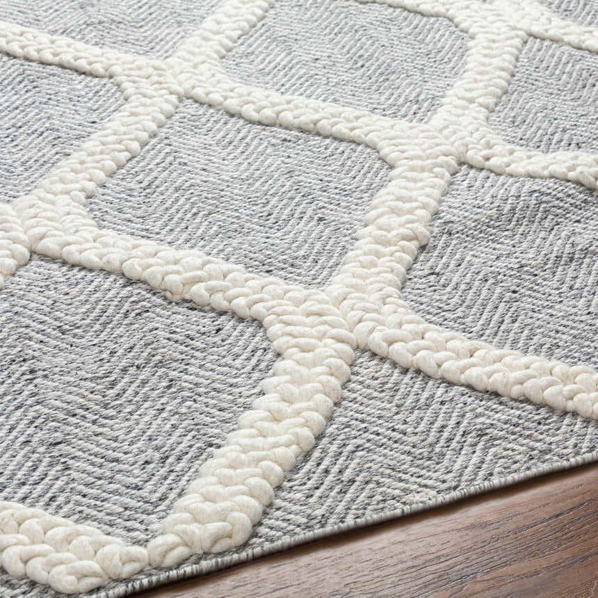 Close-up of the Della Area Rug. Gray herringbone pattern with raised, geometric, hand-woven design. Texture