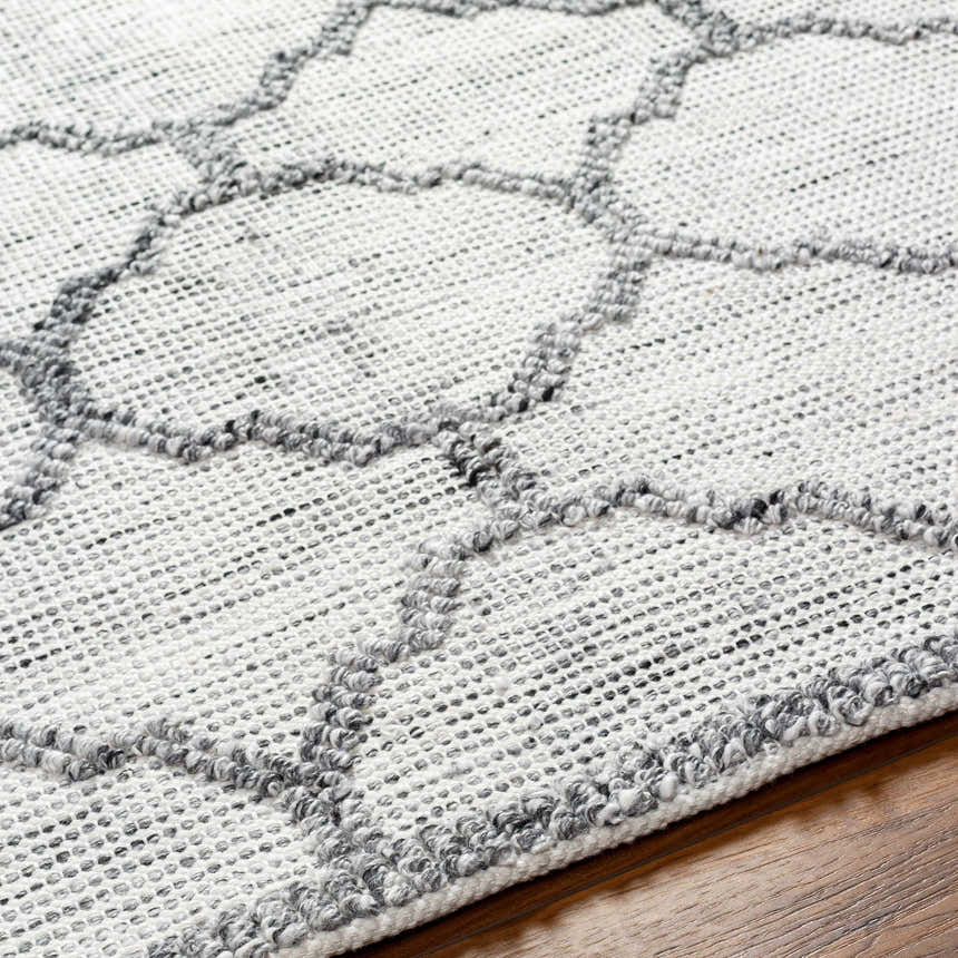 Close-up of the Dido Area Rug showcasing its charcoal and gray geometric pattern and hand-woven texture. Texture
