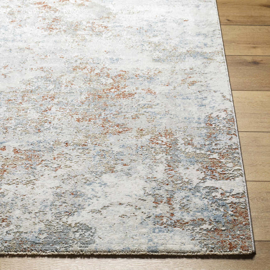 Close-up of the Dinos Thick Luxe Rug showing its gray, nutmeg, and blue abstract pattern and soft, textured pile. Front