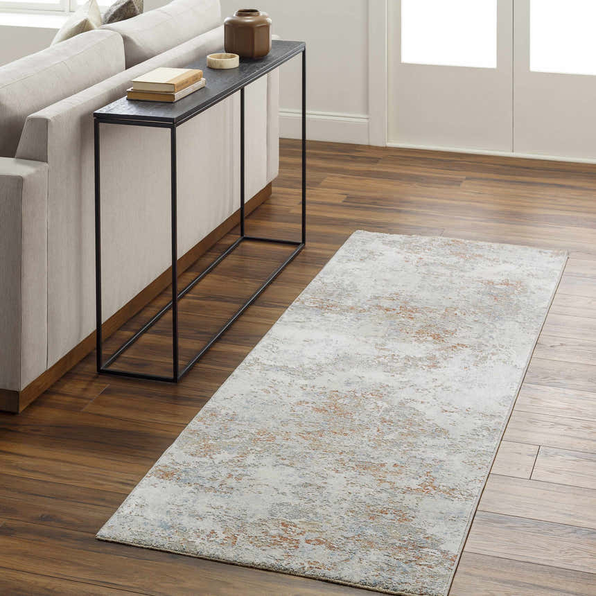 Living room scene with a Dinos Thick Luxe Rug in gray, brown, and nutmeg colors on hardwood floors. Modern sofa and console table. Roomscene-Runner