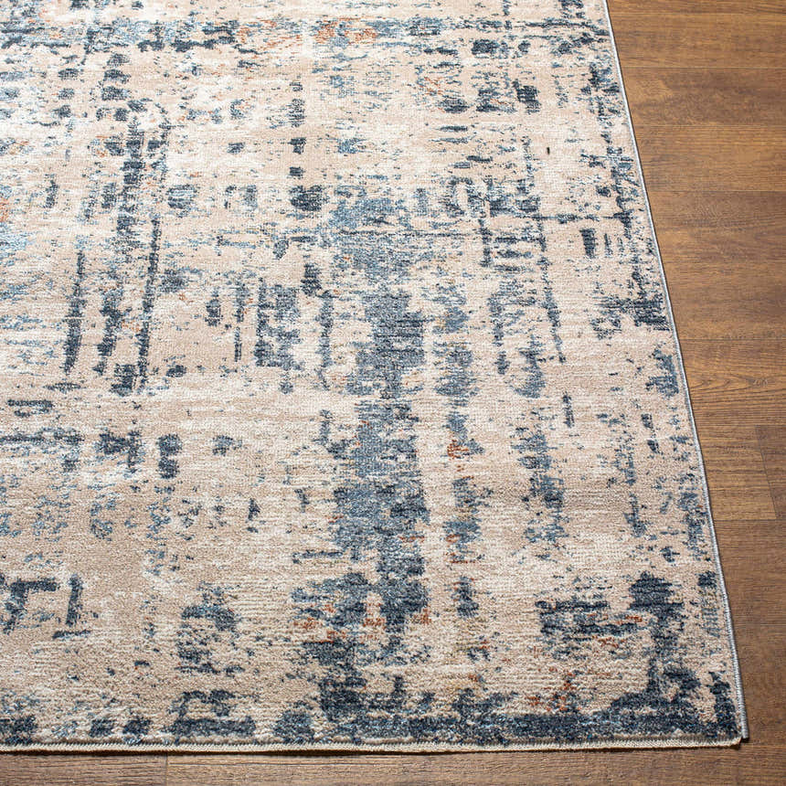 Close-up of the Dalama Area Rug. Contemporary design in dark gray, ivory, and slate blue on a wood floor. Front