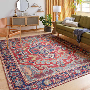 Living room scene with a red, blue, and cream Dorcas Red Performance Rug, green sofa, and wood furniture. Roomscene-Rectangle