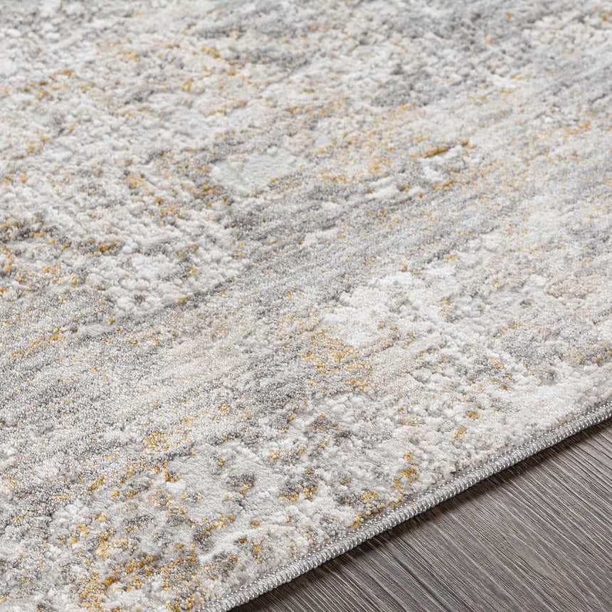 Close up of the textured Dowell Luxe Area Rug, in light gray, off white, and mustard on a wood floor. Texture