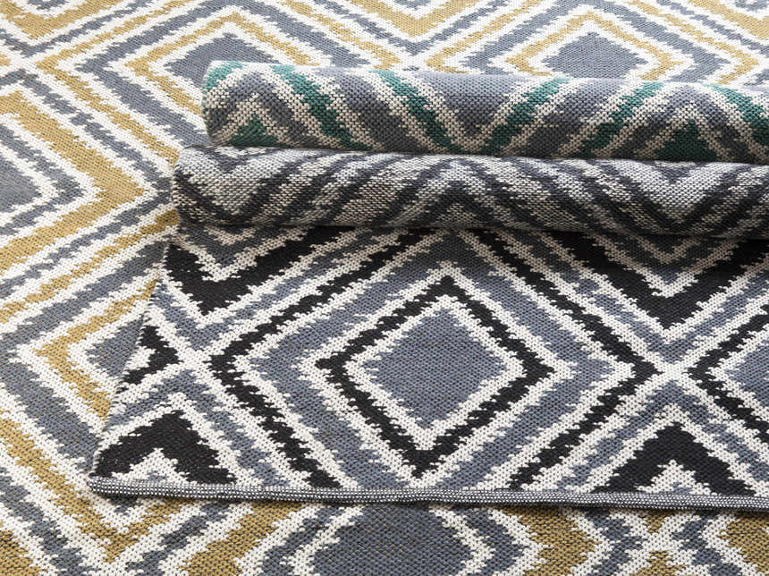 Close-up of the hand woven Druid Area Rug. Charcoal, ivory, and mustard geometric diamond pattern. 100% wool texture. Styleshot