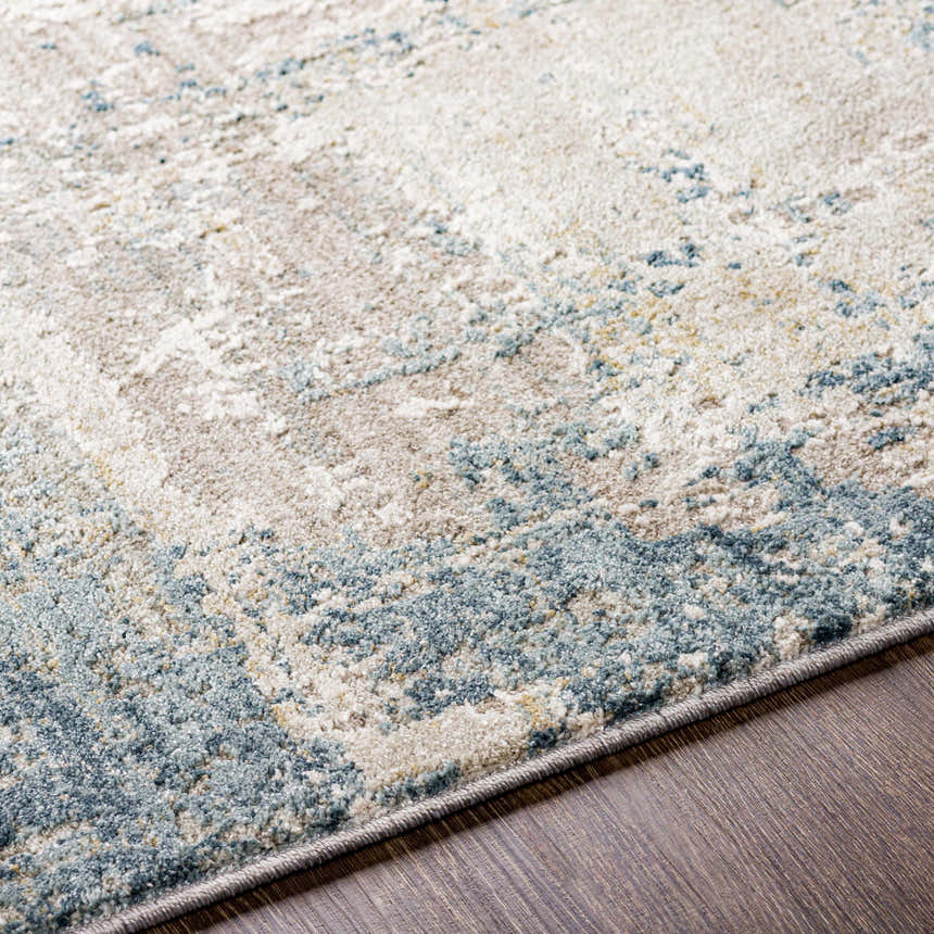 Close up of the Devonport Thick Luxe Area Rug showing its light gray, taupe, and pale blue contemporary design. Texture