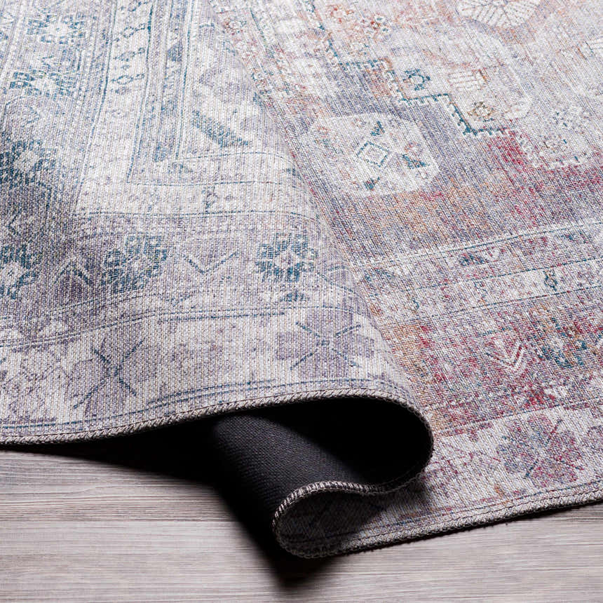 Close-up of the Baltinglass Gray Washable Rug showing its traditional, oriental pattern and chenille-polyester texture. Fold