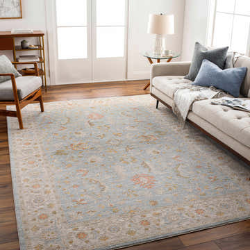 Living room scene with a taupe sofa and Edie Taupe Thick Luxe Oushak Rug with amber, pink, and gray floral pattern. Roomscene-Rectangle