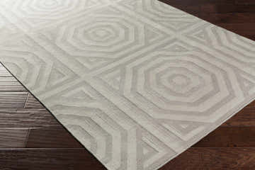 Close-up of the Edmund Area Carpet. Gray and light gray geometric pattern on a hand woven wool rug. Corner