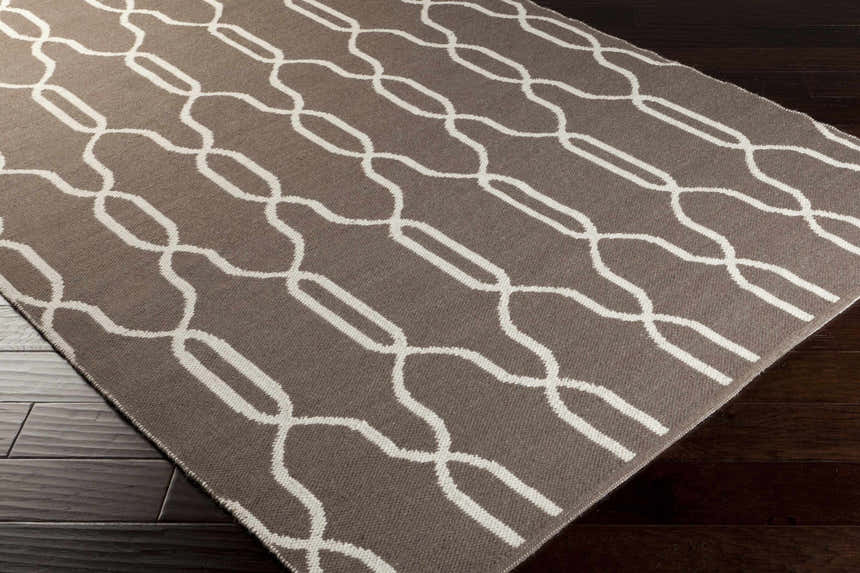 Close-up of Effie Reversible Area Carpet showing brown wool and cream geometric chain-link pattern. Corner