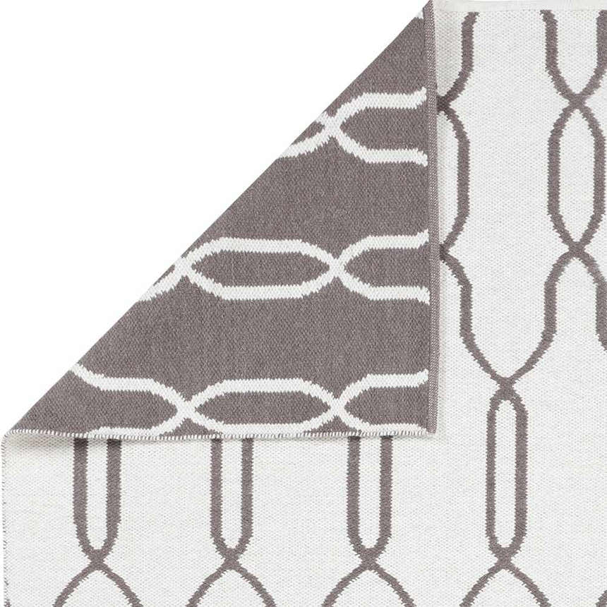 Close up of the reversible Effie Area Carpet in brown and cream showing the geometric pattern and wool texture. Swatch