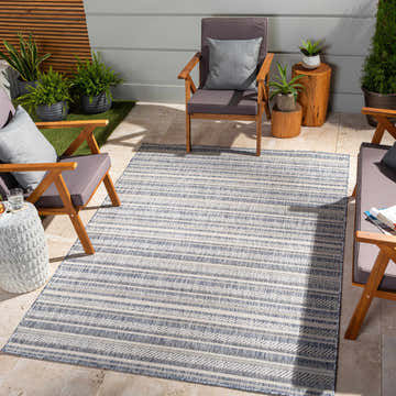 Outdoor patio scene with wood chairs and a blue and white striped Emirgazi Nordic Rug. Roomscene-Rectangle