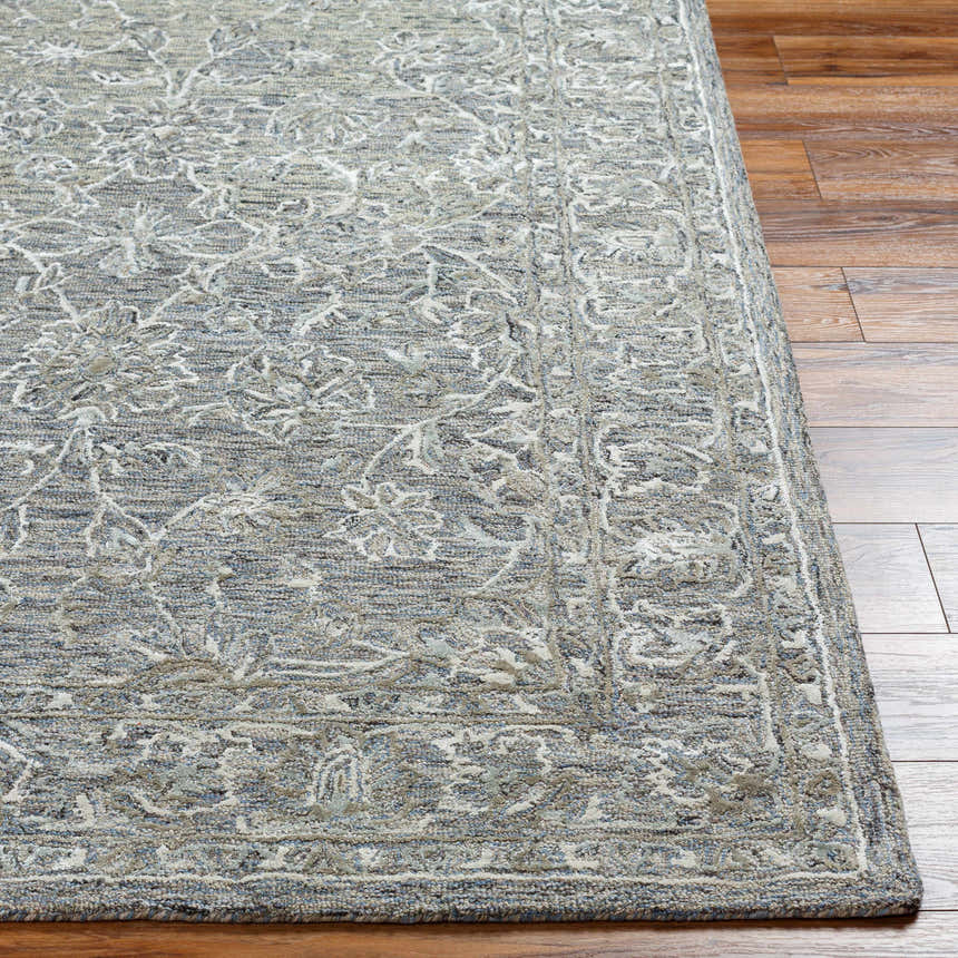 Close up of the Eriline Wool & Faux Silk Rug showing the denim, sage, and ivory floral pattern and hand-tufted texture. Front