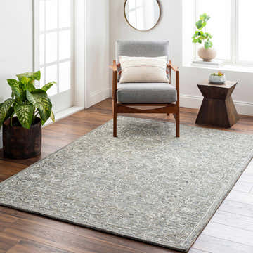 Living room scene with Eriline Wool & Faux Silk Rug in denim and ivory, gray chair, wood floors, and natural light. Roomscene-Rectangle