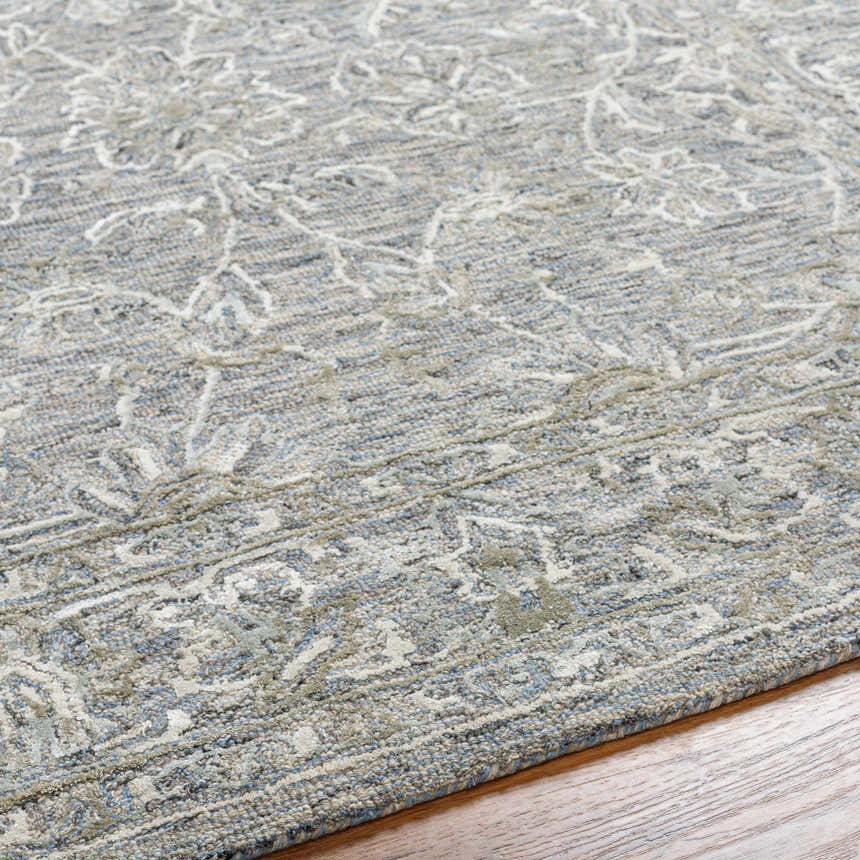 Close-up of the Eriline Wool & Faux Silk Rug. Denim, ivory, sage and taupe floral pattern rug with textured wool and viscose fibers. Texture
