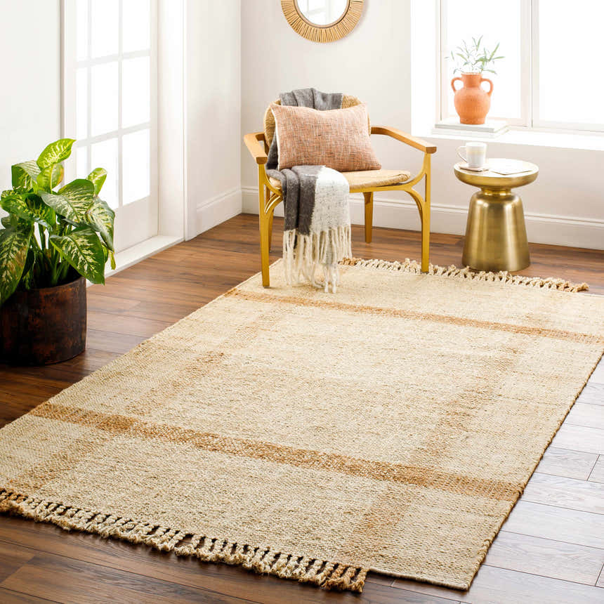 Living room scene with Errin Jute Area Rug in beige and camel. Farmhouse style with jute rug, wood floors, and natural light. Roomscene-Rectangle