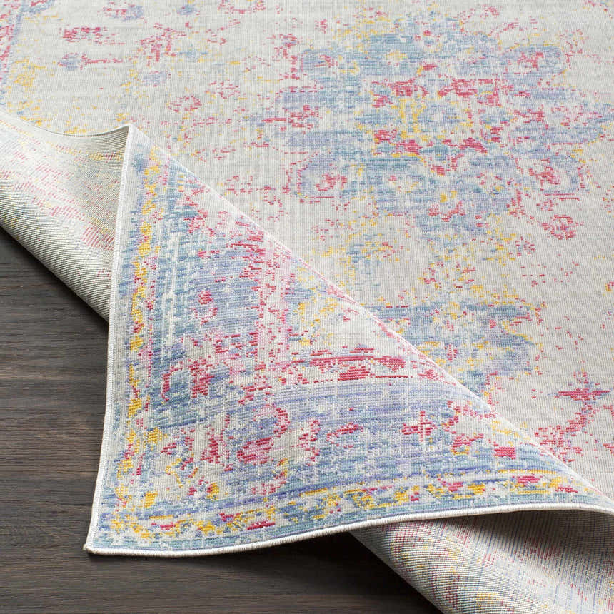 Close-up of the Eufaula Area Rug featuring a vintage-inspired design with burgundy, gray, lavender, and yellow hues. Fold