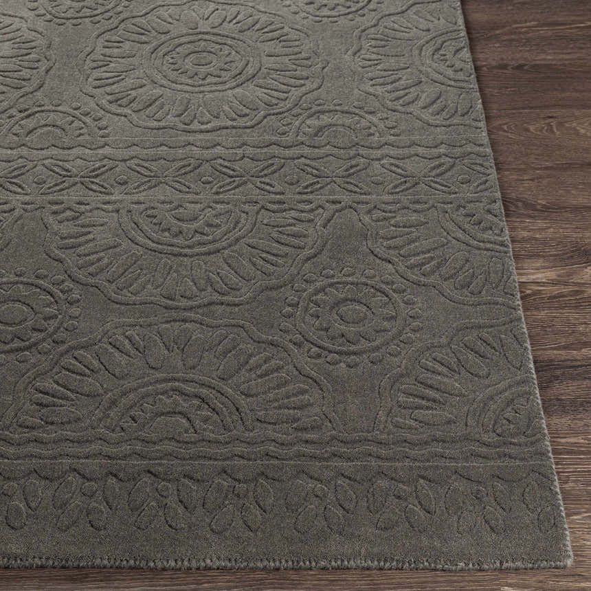 Close-up of the charcoal Eversholt Clearance Rug, a hand-loomed wool rug with a contemporary floral pattern. Front