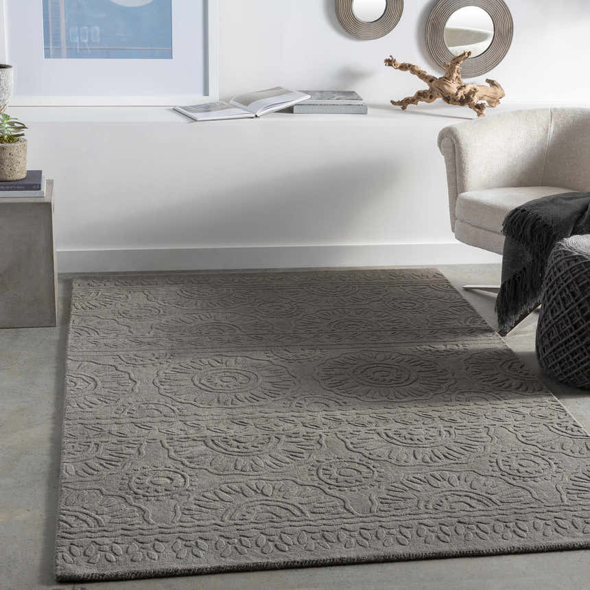 Living room scene with charcoal Eversholt Clearance Rug, neutral armchair, and modern decor. Roomscene-Rectangle