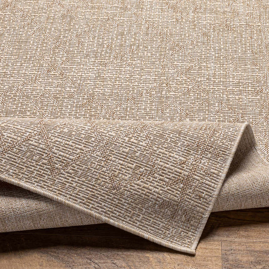 Close-up of the Maunawili Cream Nordic Rug showing its woven texture and subtle geometric pattern in beige and light brown. Fold
