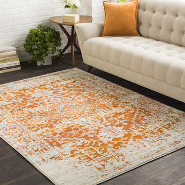 Living room scene with a Fairmount Orange Area Rug, beige sofa with orange pillow, and white brick wall. Roomscene-Rectangle