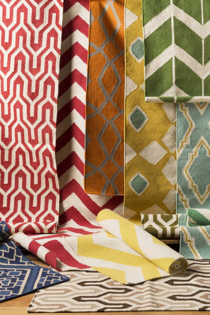 Close-up of Enniskillen Area Rugs in white, yellow, red, orange, green, and blue with geometric, hand-woven designs. Styleshot