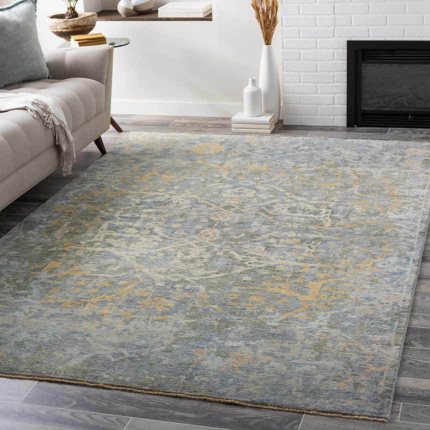 Living room scene with a blue and sage Farmingville Area Rug, beige sofa, and fireplace. Roomscene-Rectangle