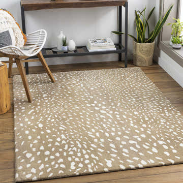 Living room scene with a tan Athena Brown Giraffe Print Wool Rug, white chair, wood floors, and console table with plants. Roomscene-Rectangle